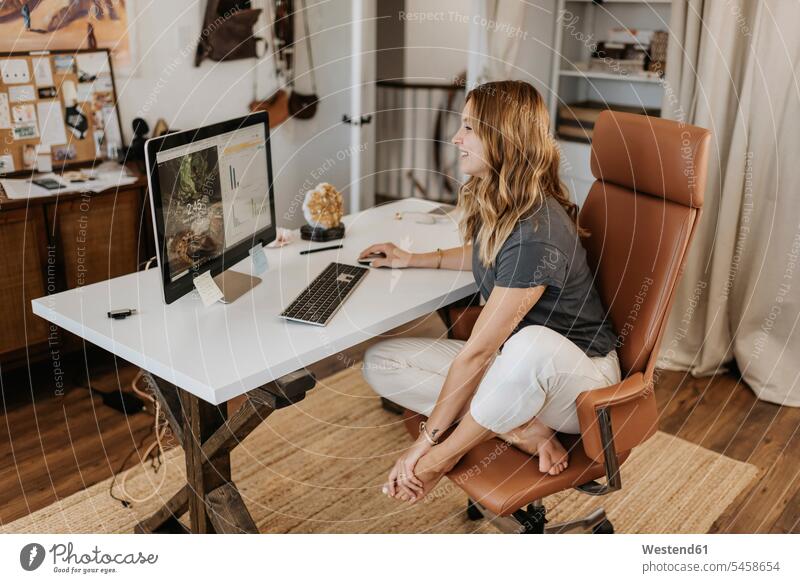 Woman using computer on desk at home color image colour image casual clothing casual wear leisure wear casual clothes Casual Attire indoors indoor shot