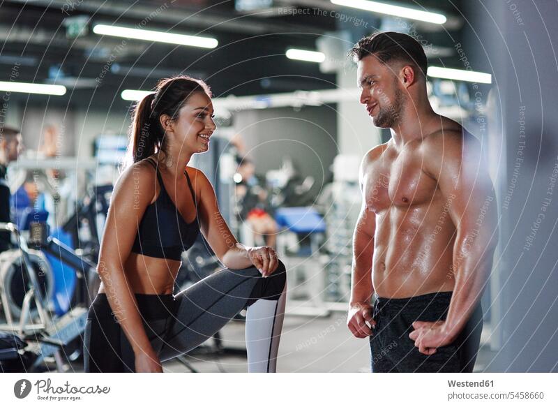 Smiling man and woman talking at the gym smiling smile couple twosomes partnership couples speaking people persons human being humans human beings content
