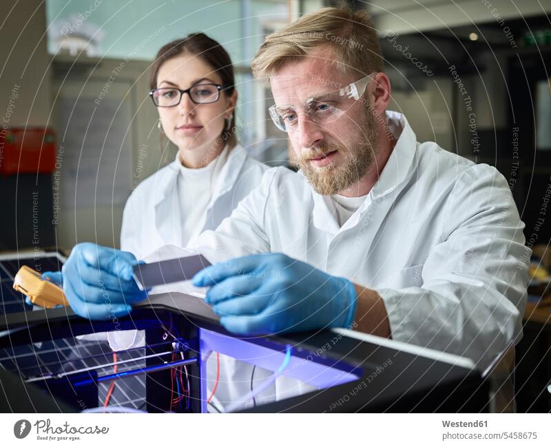 Two technicians working on solar cell in lab human human being human beings humans person persons caucasian appearance caucasian ethnicity european 2 2 people