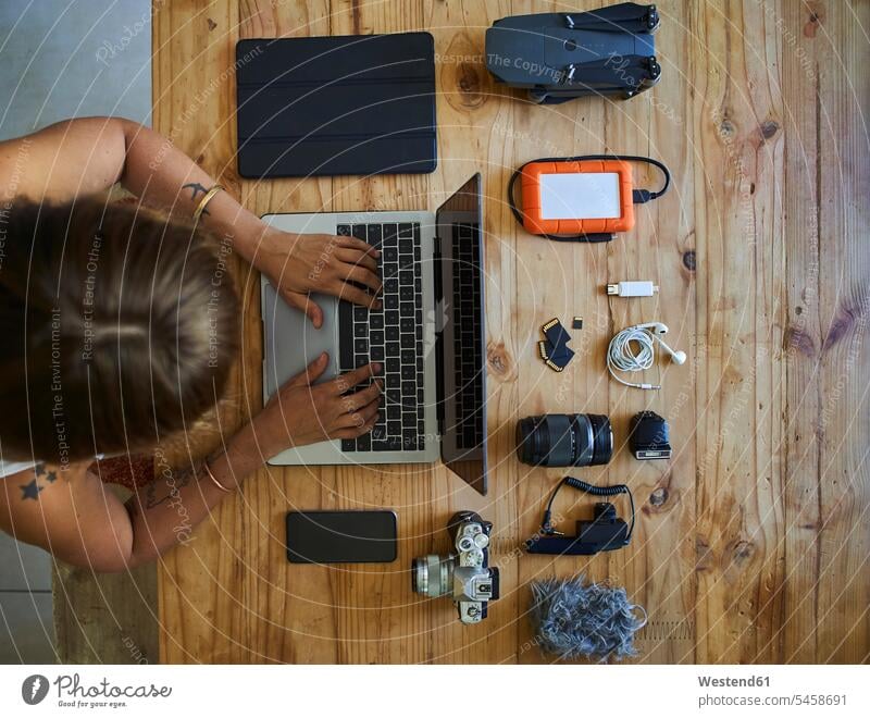 Person sitting at table with photografic equipment, using laptop, overhead view Occupation Work job jobs profession professional occupation photographers Tables