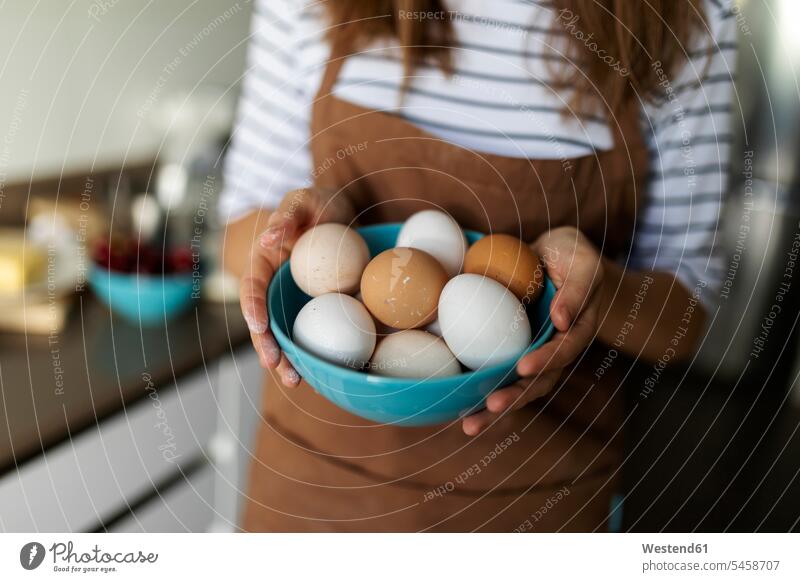 Close-up of young woman holding eggs in kitchen at home color image colour image Spain indoors indoor shot indoor shots interior interior view Interiors