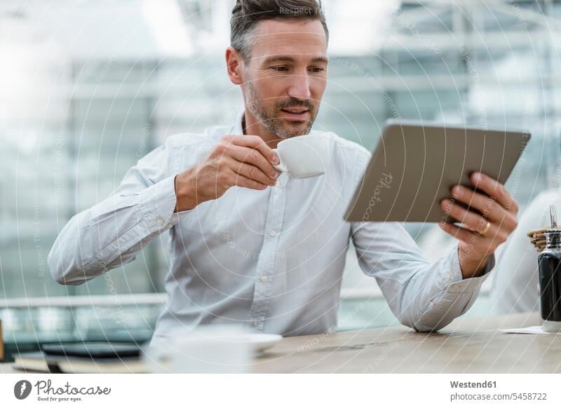 Businessman using tablet in a cafe human human being human beings humans person persons caucasian appearance caucasian ethnicity european 1 one person only