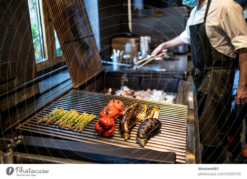 Chef wearing protective face mask preparing grilled vegetables in restaurant kitchen human human being human beings humans person persons caucasian appearance