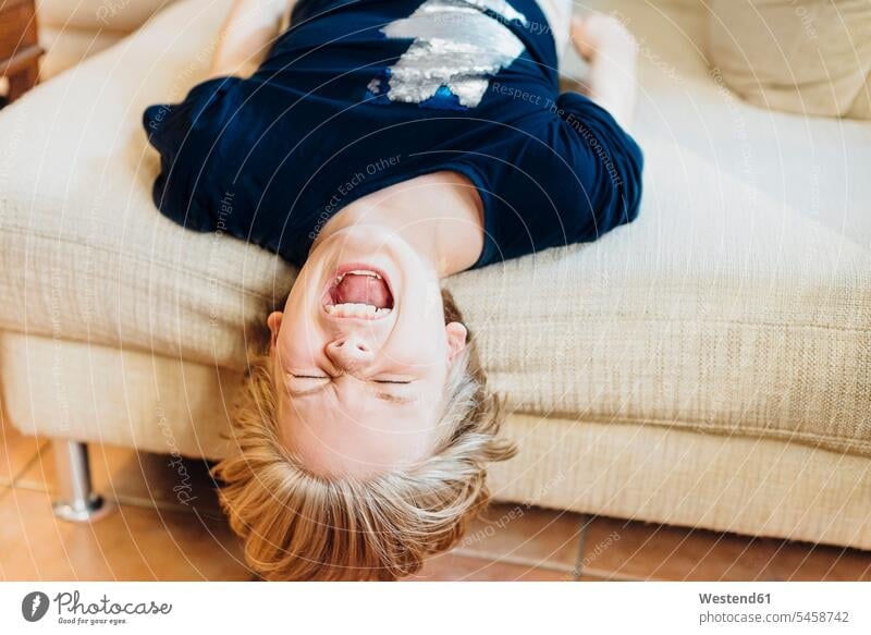 Screaming boy lying on couch T- Shirt t-shirts tee-shirt couches settee settees sofa sofas laying down lie lying down at home free time leisure time loud