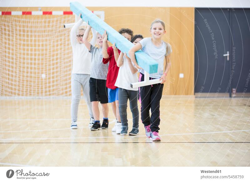 Pupils carrying balance beam in gym class student pupils balance beams physical education physical education class school schools schoolchildren