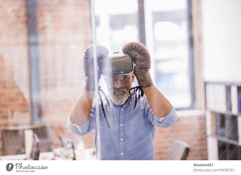 Portrait of businessman with Virtual Reality Glasses and boxing gloves in the office VR glasses Virtual-Reality Glasses virtual reality headset vr headset