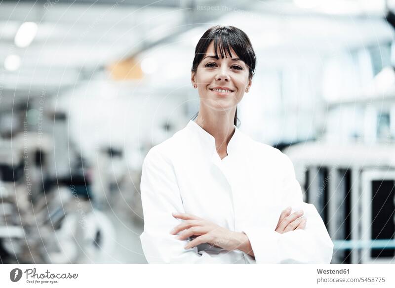 Smiling female scientist standing with arms crossed in bright laboratory color image colour image Germany indoors indoor shot indoor shots interior
