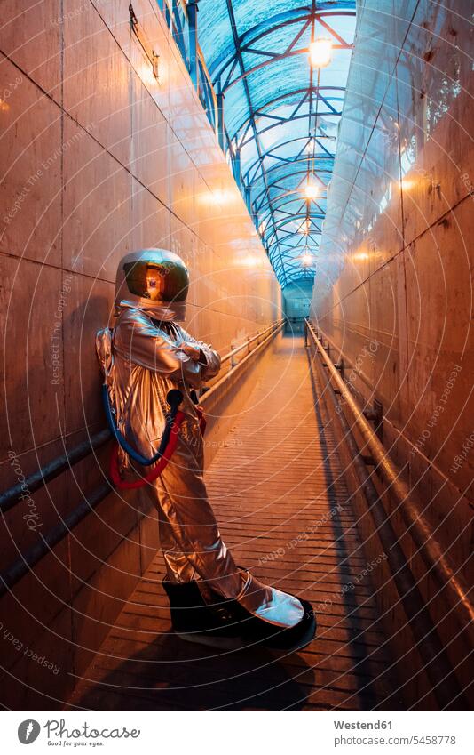 Spaceman in the city at night standing in narrow passageway spaceman spacemen astronaut astronauts town cities towns by night nite night photography