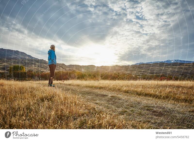 Chile, Valle Chacabuco, Parque Nacional Patagonia, woman standing in steppe landscape at sunset mountain mountains females women veld sunsets sundown landscapes