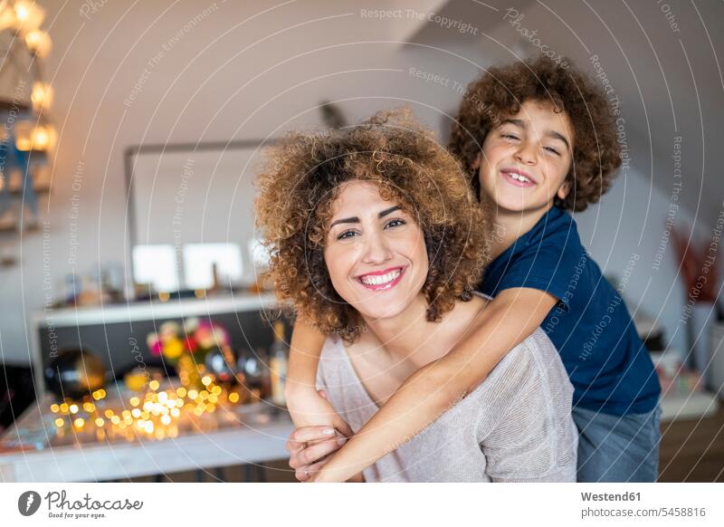 Mother with son, piggyback at home hold smile play delight enjoyment Pleasant pleasure Cheerfulness exhilaration gaiety gay glad Joyous merry happy closeness