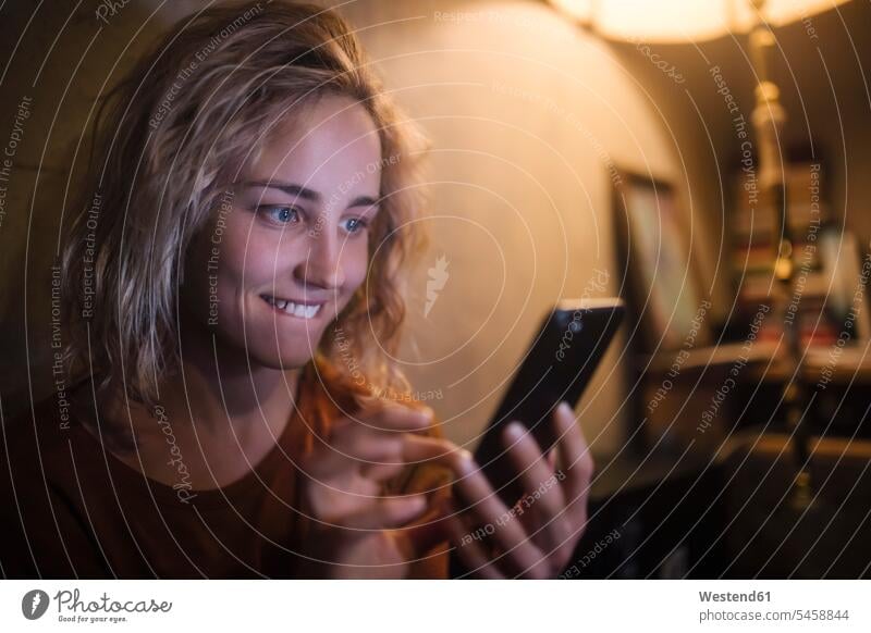 Portrait of young woman using smartphone at home telecommunication phones telephone telephones cell phone cell phones Cellphone mobile mobile phones mobiles