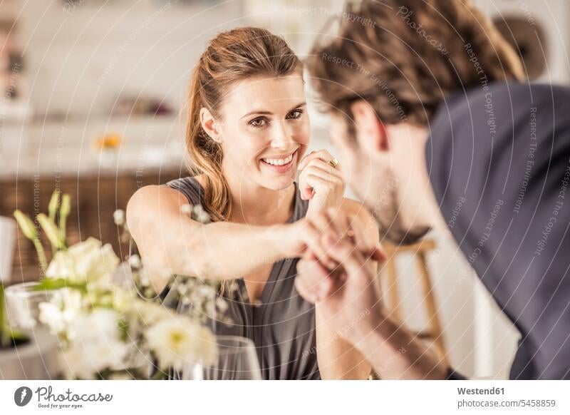 Smiling young woman looking at boyfriend kissing her hand dresses hold smile delight enjoyment Pleasant pleasure indulgence indulging savoring happy Emotions