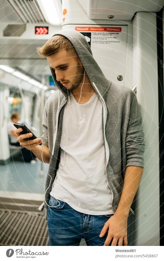 Young man using smartphone in metro Smartphone iPhone Smartphones the metro use young man young men mobile phone mobiles mobile phones Cellphone cell phone