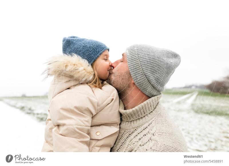 Father kissing daughter in winter kisses daughters hibernal father pa fathers daddy dads papa child children family families people persons human being humans