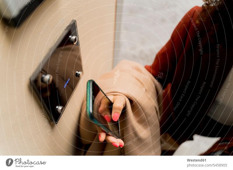 Close-up of woman opening door with smartphone telecommunication phones telephone telephones cell phone cell phones Cellphone mobile mobile phones mobiles hold