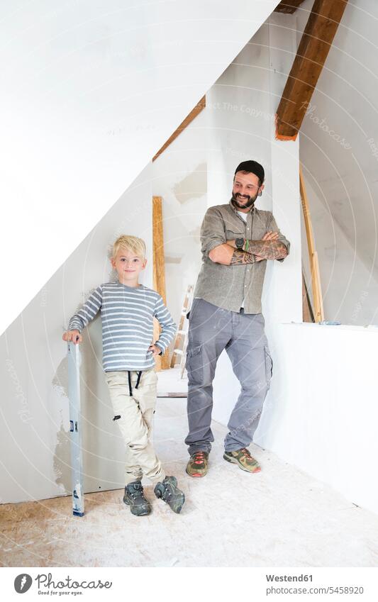 Portrait of smiling father and son working on loft conversion pa fathers daddy dads papa Attic Lofts Attics portrait portraits sons manchild manchildren At Work