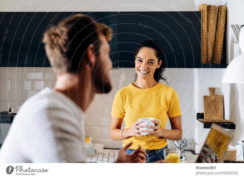 Portrait of young woman smiling at boyfriend with laptop in the kitchen T- Shirt t-shirts tee-shirt computers Laptop Computer Laptop Computers laptops notebook