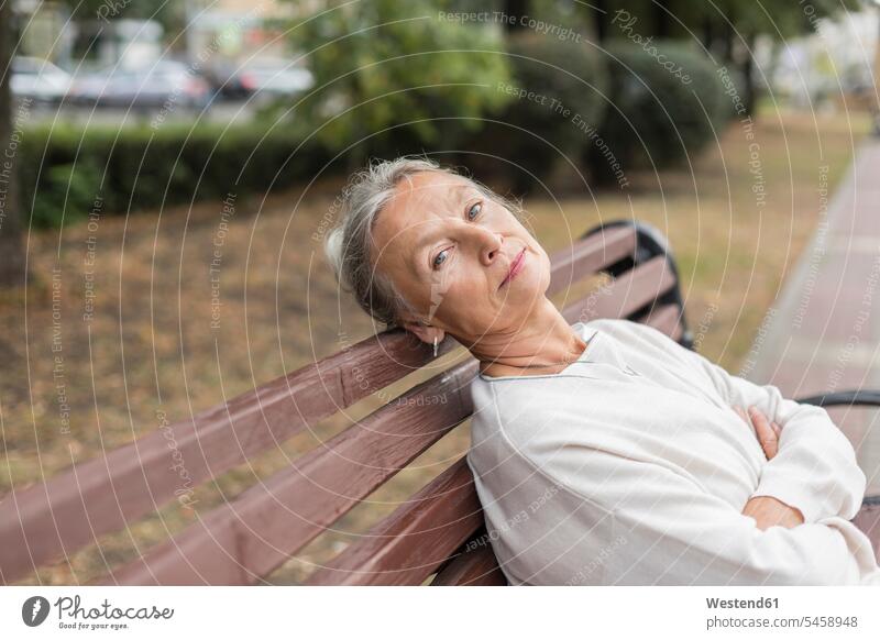 Portrait of senior woman relaxing on a bench senior women elder women elder woman old benches sitting Seated relaxed relaxation portrait portraits females