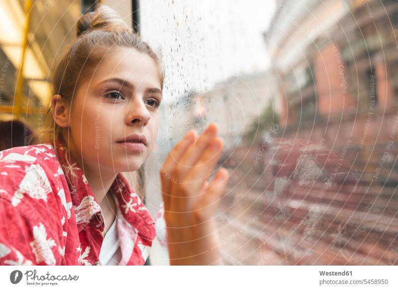Young woman travelling by train and looking out of the window windows pane panes window glass window glasses Window Pane windowpanes transport railroad subway