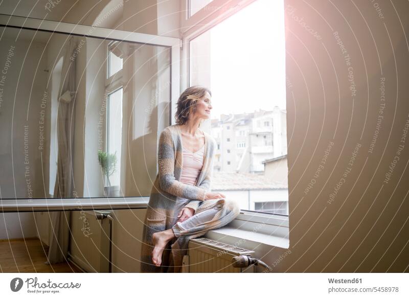 Mature woman looking out of window females women view seeing viewing day daylight shot daylight shots day shots daytime windows Adults grown-ups grownups adult