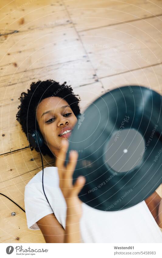 Young woman at home listening vinyl records, lying on ground African-American Ethnicity Afro-American African American Ethnicity African Americans