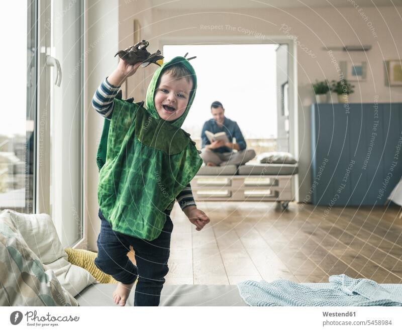 Happy boy in a costume playing with toy figure at home happiness happy fancy dress fancy-dress costume Fancy Dress Costumes disguise costumes animal figurine
