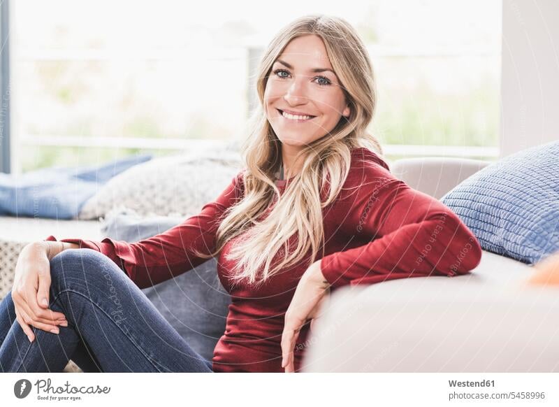 Portrait of smiling blond woman relaxing at home human human being human beings humans person persons celibate celibates singles solitary people solitary person
