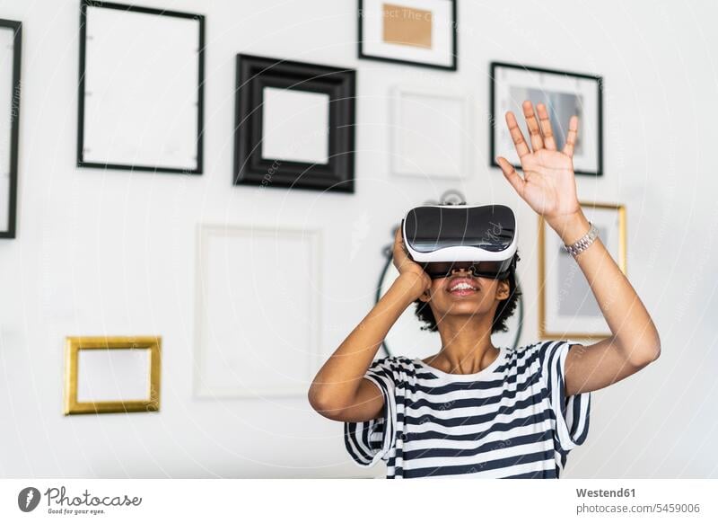 Young woman with VR glasses at home human human being human beings humans person persons celibate celibates singles solitary people solitary person frame frames