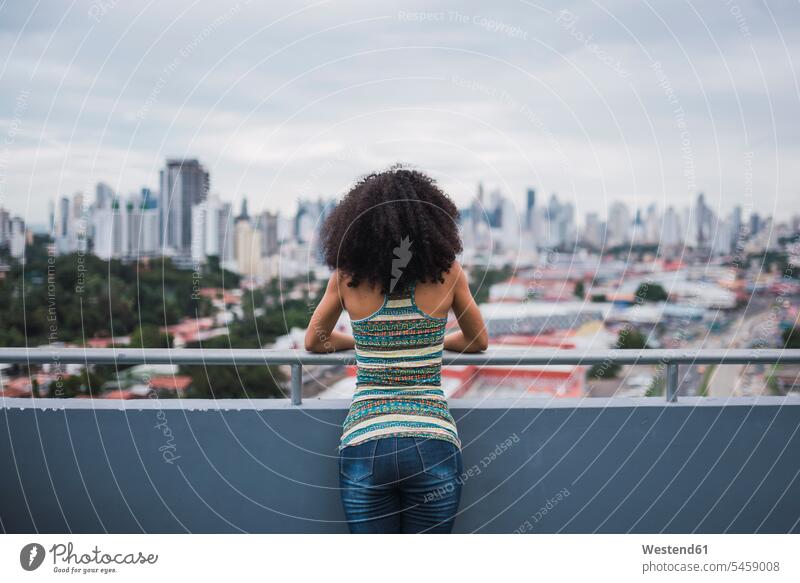 Panama, Panama City, back view of young woman standing on balcony looking at view seeing viewing balconies females women Adults grown-ups grownups adult people