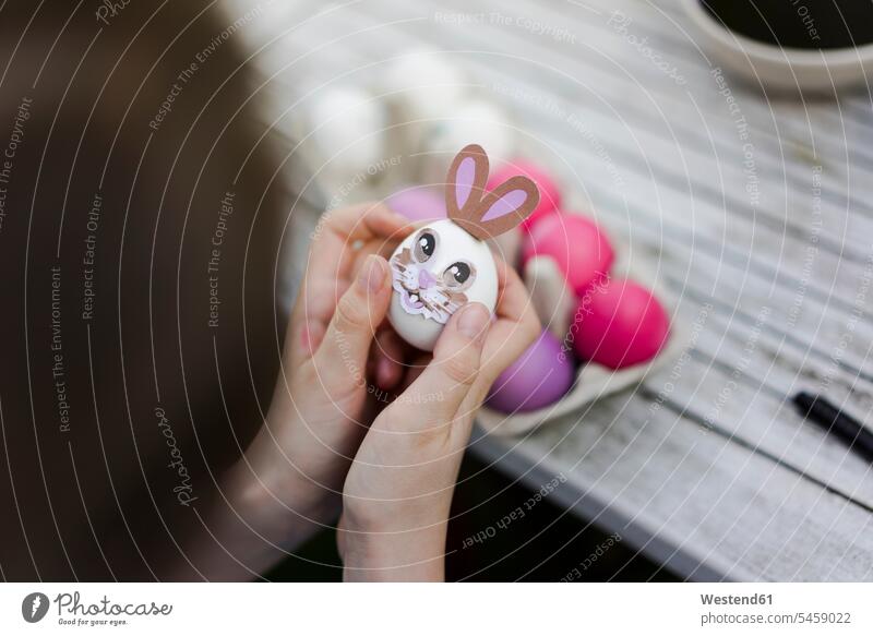 Close-up of girl decorating Easter egg on garden table human human being human beings humans person persons caucasian appearance caucasian ethnicity european 1