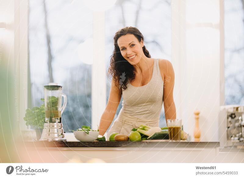 Fit woman standing in kitchen, preparing healthy smoothie human human being human beings humans person persons caucasian appearance caucasian ethnicity european