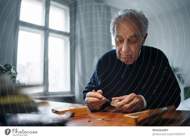 Senior man repairing a watch at home windows jumper sweater Sweaters watches Tables clock unit devices Tool Kit tools Seated sit experienced Experiences