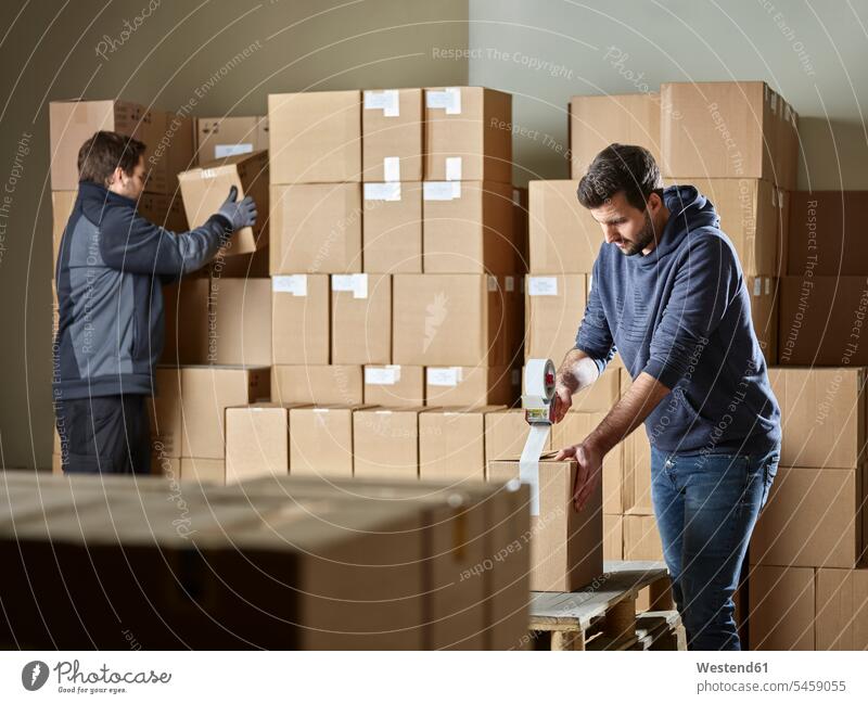 Workers closing packages with package tape worker blue collar worker workers blue-collar worker close parcel packet packets parcels Job Occupation plant factory