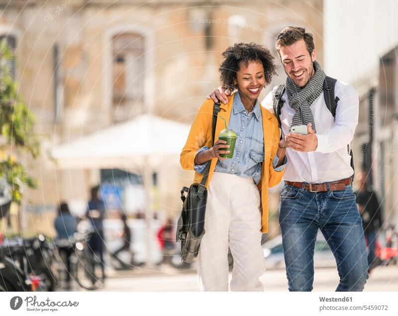 Happy young couple looking at smartphone in the city human human being human beings humans person persons caucasian appearance caucasian ethnicity european 2