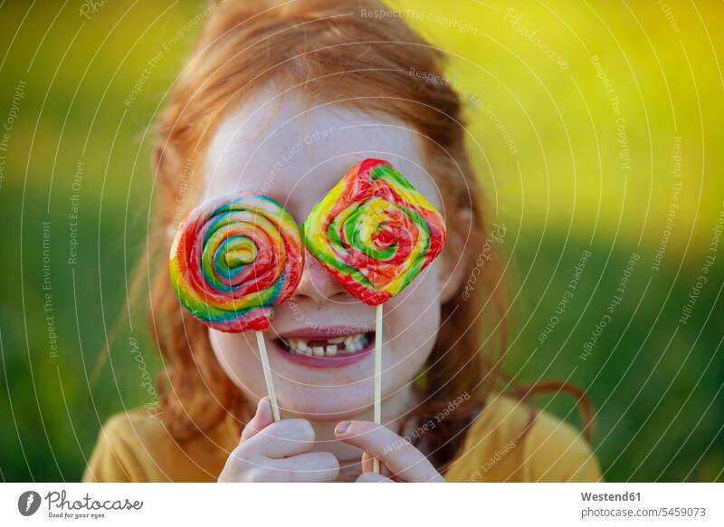 Happy girl covering her eyes with lollipops Lollipop Lollipops Lolly portrait portraits females girls Sweets Candies Sweet Food foods food and drink Nutrition