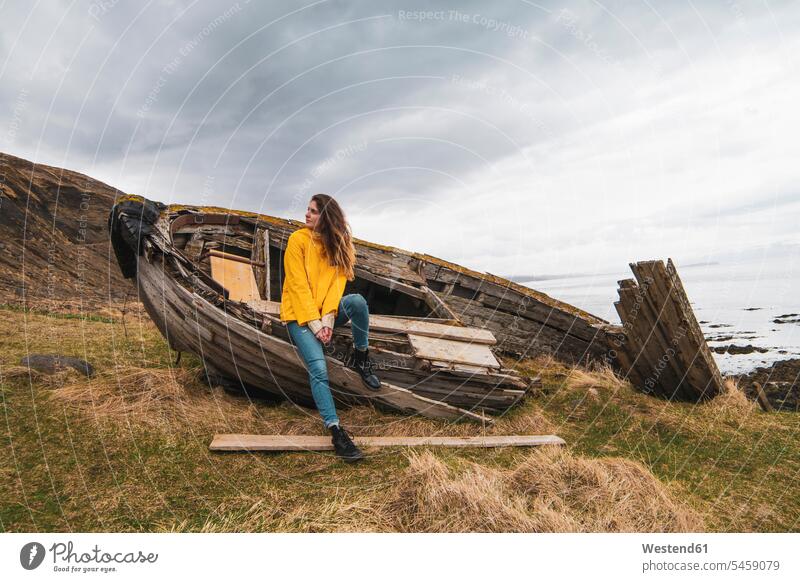 Iceland, woman in boat wreck at the coast wrecks boats coastline shoreline females women vessel water vehicle Adults grown-ups grownups adult people persons