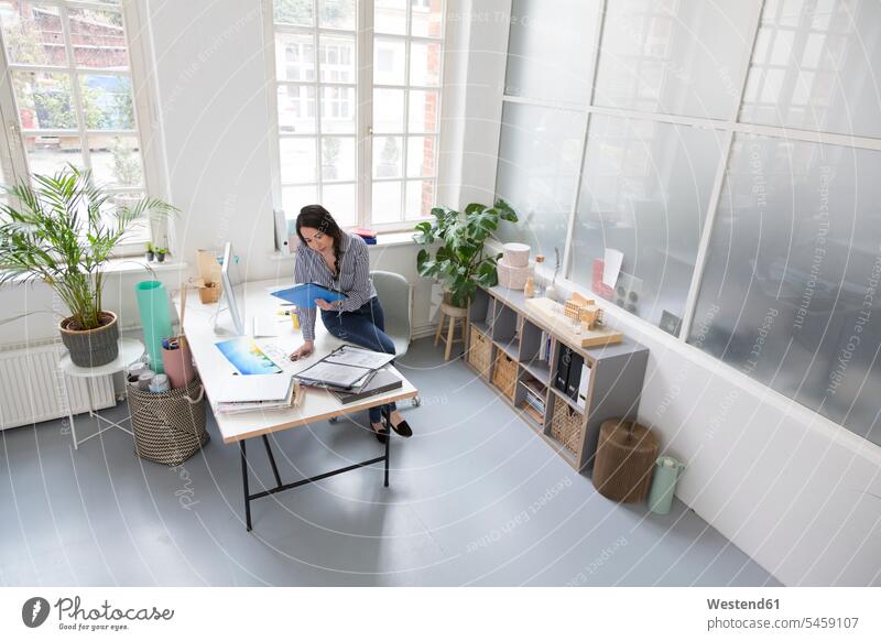 Woman working at desk in a loft office At Work woman females women offices office room office rooms lofts desks Adults grown-ups grownups adult people persons