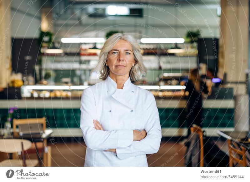 Proud business owner standing in her bistro with arms crossed business life business world business person businesspeople business woman business women