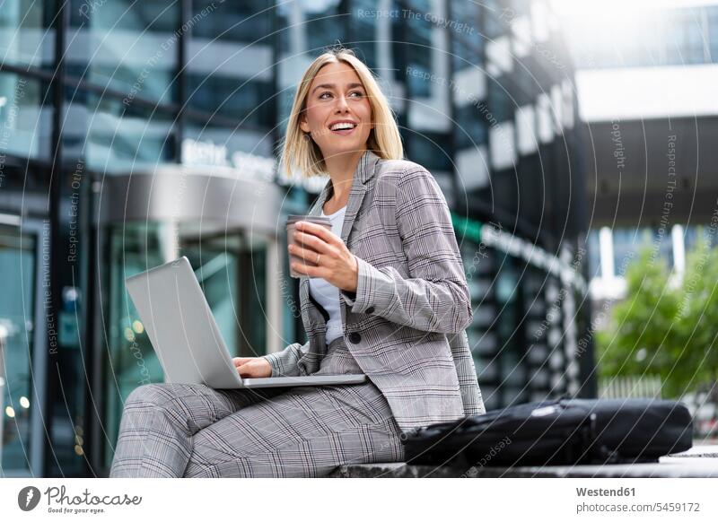 Smiling young businesswoman using laptop in the city Occupation Work job jobs profession professional occupation business life business world business person