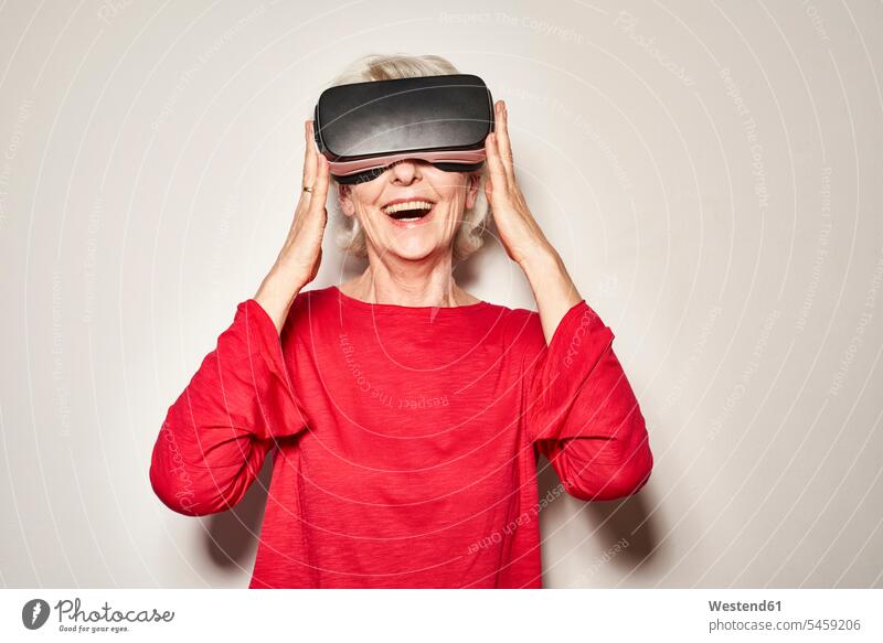 Portrait of laughing mature woman wearing Virtual Reality Glasses jumper sweater Sweaters delight enjoyment Pleasant pleasure happy colour colours explore
