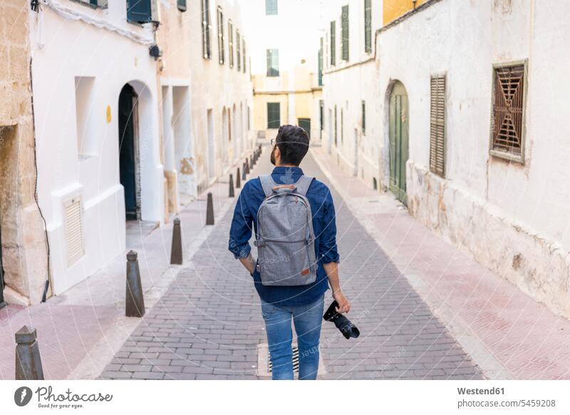 Back view of man with camera exploring the city, Mao, Menorca, Spain touristic tourists back-pack back-packs backpacks rucksack rucksacks cameras photograph go