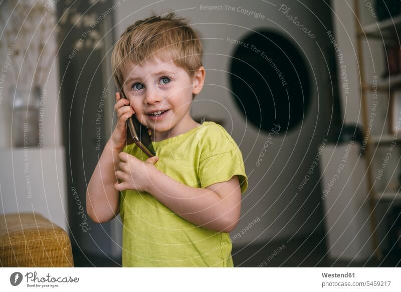 Portrait of smiling little boy on the phone at home T- Shirt t-shirts tee-shirt telecommunication phones telephone telephones cell phone cell phones Cellphone
