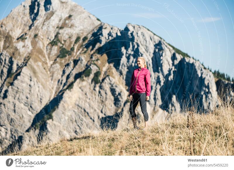 Austria, Tyrol, smiling female athlete standing on alpine meadow mountain range mountains mountain ranges sportswoman athletes sportswomen female athletes