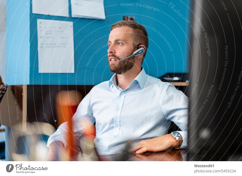 Businessman with headset at desk in office human human being human beings humans person persons caucasian appearance caucasian ethnicity european 1
