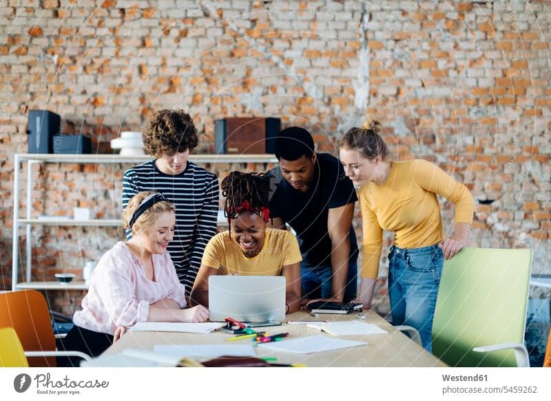 Young people working together at table using laptop human human being human beings humans person persons caucasian appearance caucasian ethnicity european