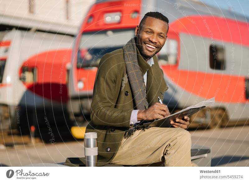 Portrait of happy businessman with reusable cup and documents waiting for the train Occupation Work job jobs profession professional occupation business life