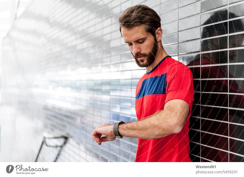 Man having a break from running checking the time on a smartwatch man men males Time smart watch Adults grown-ups grownups adult people persons human being