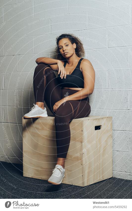 Portrait of confident athletic young woman sitting on a box human human being human beings humans person persons Mixed Race mixed race ethnicity