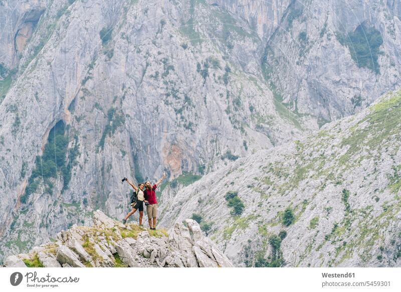 Carefree couple admiring the view while standing on mountain at Ruta Del Cares, Asturias, Spain color image colour image outdoors location shots outdoor shot