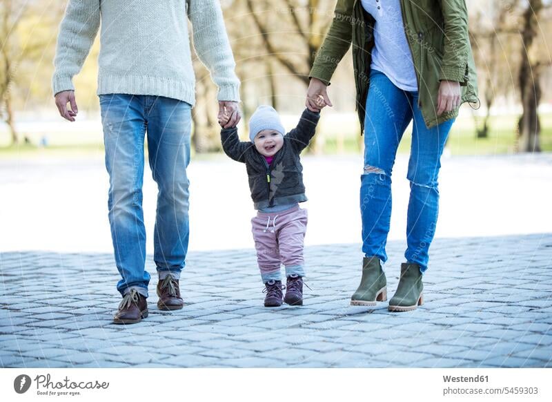 Portrait of girl walking hand in hand with parents portrait portraits baby girls female going babies infants people persons human being humans human beings
